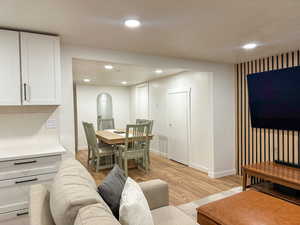 Living area with arched walkways, light wood-type flooring, and recessed lighting