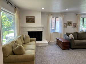 Carpeted living room with a fireplace and recessed lighting