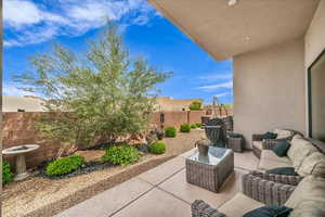 Fenced backyard with an outdoor hangout area, a patio area, and grilling area