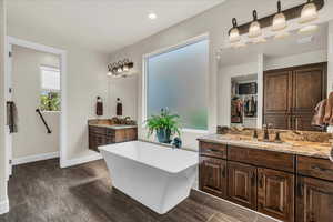 Full bath featuring a freestanding tub, vanity, and a walk in closet