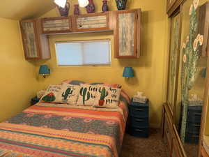 Bedroom with carpet and vaulted ceiling