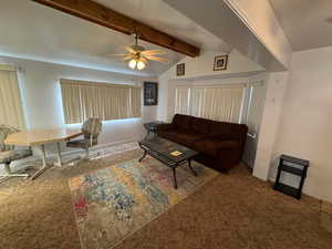 Carpeted living room with a ceiling fan and baseboards