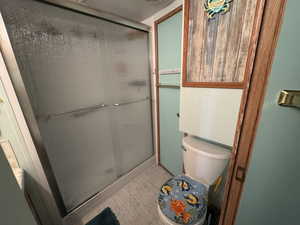 Full bath with wood finished floors and a stall shower