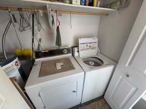 Laundry room featuring independent washer and dryer and water heater