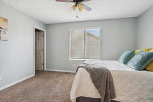 Carpeted bedroom with baseboards and ceiling fan