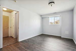 Spare room featuring a smoke detector and dark wood-style flooring