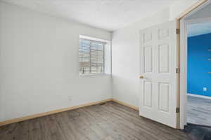 Unfurnished bedroom with wood finished floors and a textured ceiling