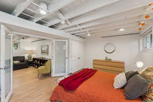 Bedroom featuring light wood-style flooring, multiple windows, and french doors
