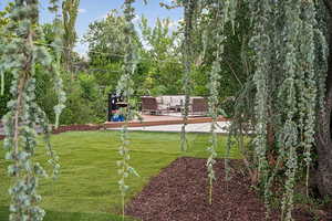 View of green lawn featuring a wooden deck and an outdoor hangout area
