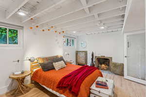 Bedroom featuring wood finished floors and beam ceiling