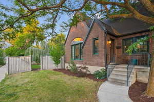View of front facade featuring a shingled roof and brick siding