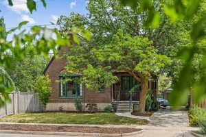 View of front of home with a gate, brick siding, and a porch