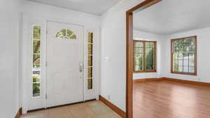 Entrance foyer with baseboards and light tile patterned flooring