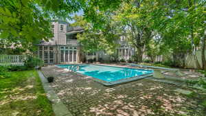 View of swimming pool with french doors and a patio area