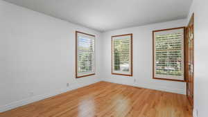 Unfurnished room with light wood-style flooring and baseboards