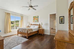 Bedroom featuring dark wood-style flooring, high vaulted ceiling, and a ceiling fan