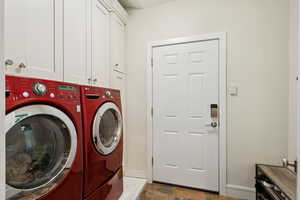 Washroom featuring washer and clothes dryer and cabinet space