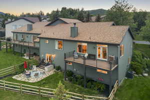 Back of property with a patio, a fenced backyard, a fire pit, a chimney, and roof with shingles