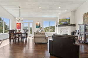Living area featuring a chandelier, wood ceiling, and dark wood-style flooring