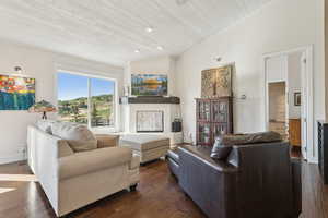 Living room with lofted ceiling, wooden ceiling, and dark wood finished floors
