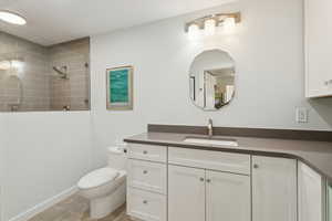 Bathroom with vanity, tiled shower, and tile patterned floors