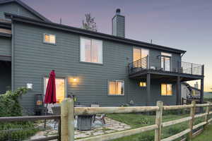 Rear view of property with a balcony, a chimney, and a patio area