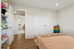 Bedroom featuring wood finished floors, recessed lighting, and a closet