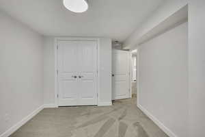Unfurnished bedroom featuring light colored carpet and a closet