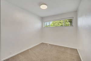 Empty room with carpet and baseboards