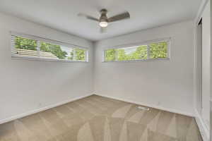 Spare room with light carpet and a ceiling fan
