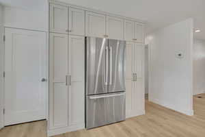 Kitchen featuring freestanding refrigerator, light wood finished floors, and recessed lighting