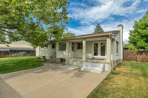 View of front of home featuring a chimney, a patio area, and french doors