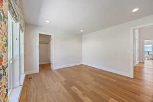 Unfurnished bedroom with light wood-type flooring, recessed lighting, and a walk in closet