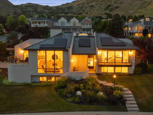 The crisp metal-roofed silhouette and floor-to-ceiling windows present a modern yet inviting façade.