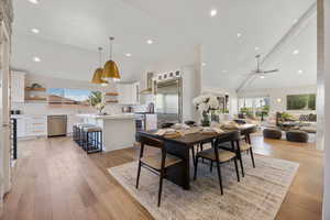 Dining area with healthy amount of natural light, ceiling fan, light wood-type flooring, high vaulted ceiling, and recessed lighting