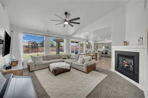 Living room with ceiling fan, lofted ceiling, light carpet, a tile fireplace, and recessed lighting