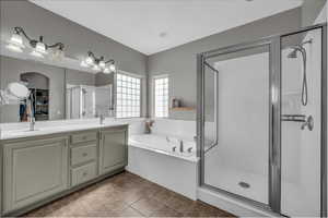 Bathroom with a stall shower, a garden tub, and double vanity