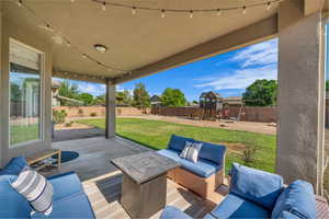 Fenced backyard featuring a patio, an outdoor hangout area, and a playground