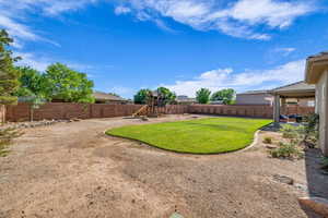 Fenced backyard with a playground and a patio area