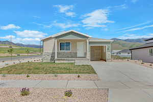 View of front of home with stone siding, driveway, a mountain view, and an attached garage