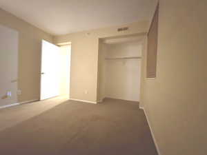 Unfurnished bedroom with a closet, carpet floors, and baseboards