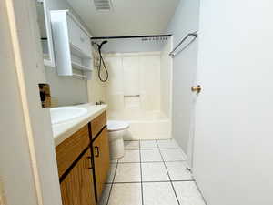 Full bathroom with vanity, toilet, tile patterned flooring, bathtub / shower combination, and baseboards