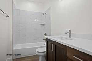 Bathroom with vanity, wood finished floors, and shower / bath combination