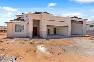 View of front of home with stucco siding and a garage