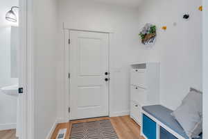 Mudroom with light wood-type flooring and baseboards