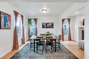 Dining space with light wood-style flooring, recessed lighting, and a glass covered fireplace