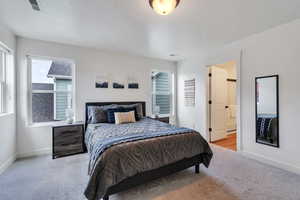 Carpeted bedroom with baseboards and connected bathroom
