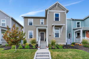 View of front of property with a front yard and board and batten siding
