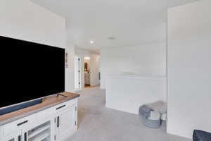 Unfurnished living room featuring light carpet and recessed lighting