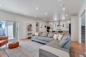 Living area featuring light wood finished floors, recessed lighting, and stairway